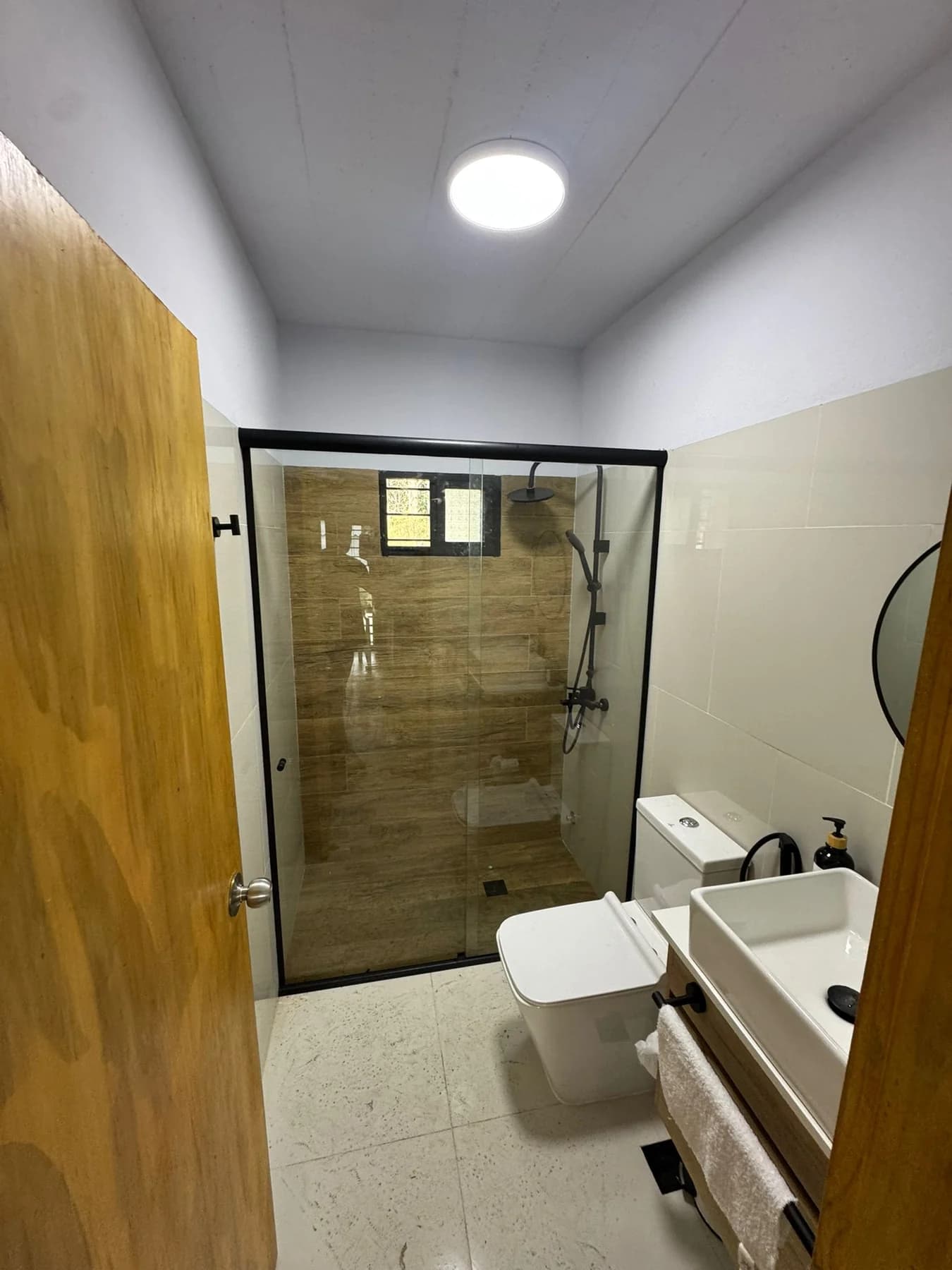 Mampara frontal negra en baño moderno